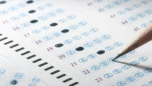 A man completes a multiple choice exam questionnaire. A man completes a multiple choice exam questionnaire.